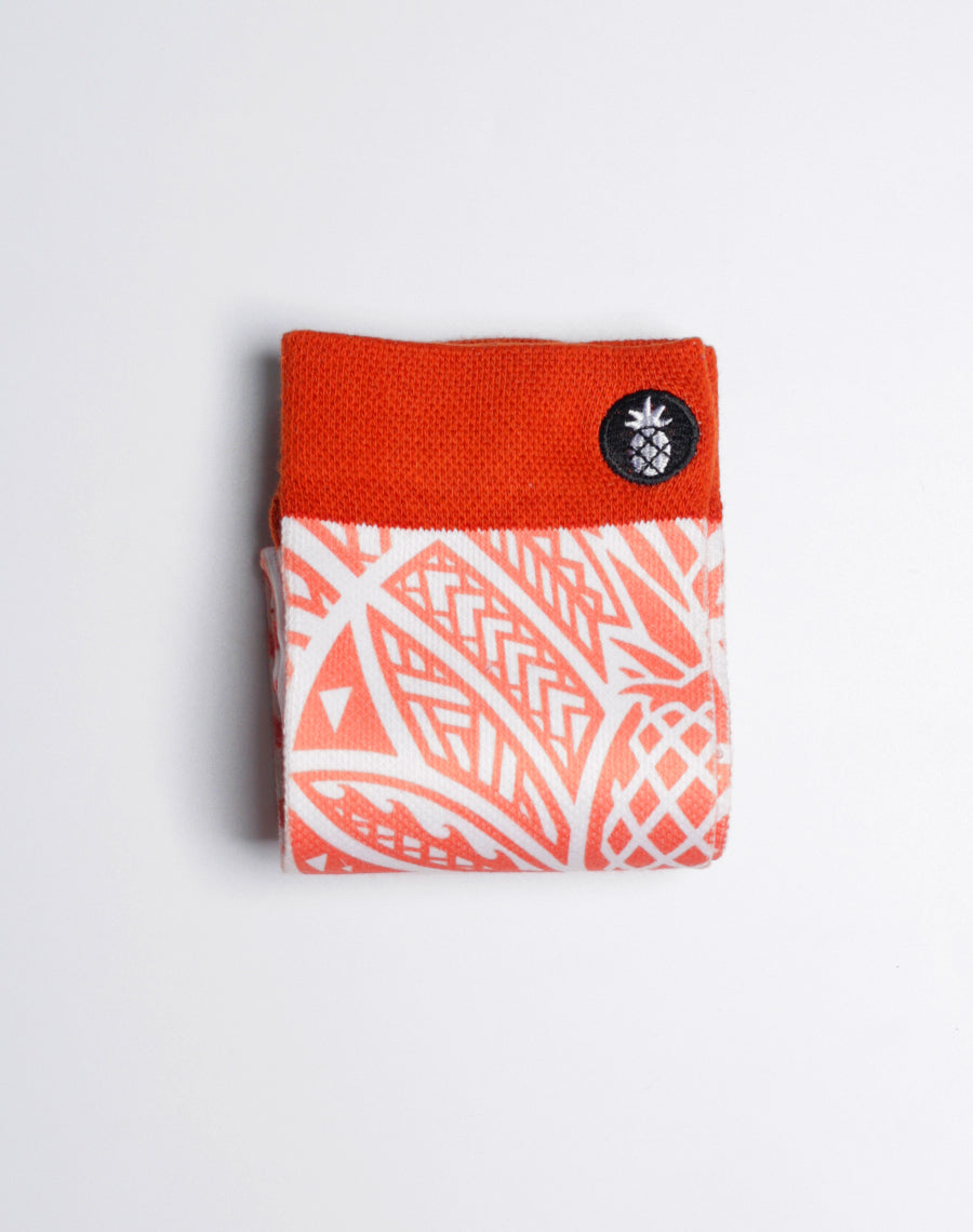 Maui Brewing Co. branded crew socks featuring vibrant orange pineapple graphics.