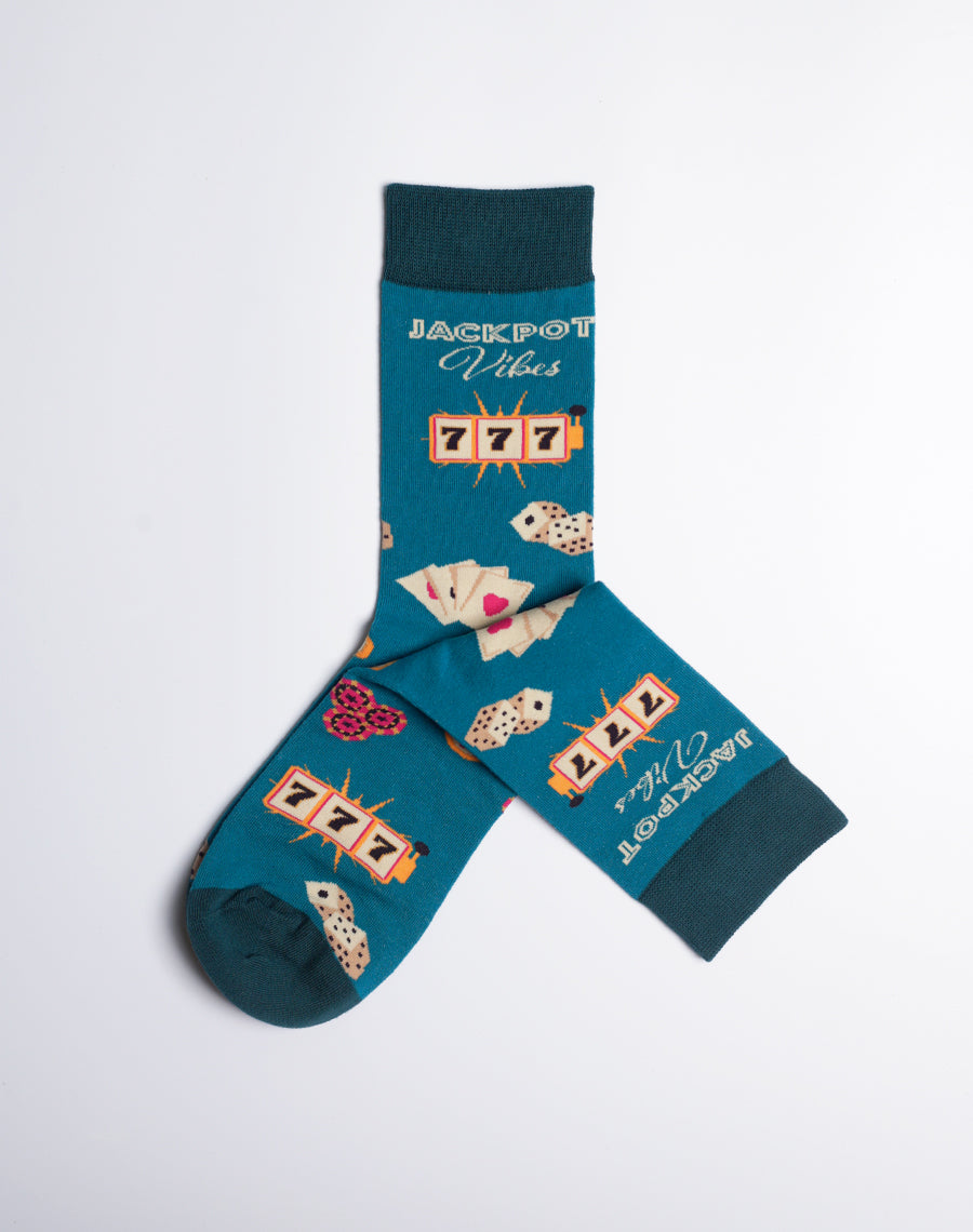 Teal crew socks featuring a Las Vegas jackpot theme with slot machine icons, playing cards, dice, and the text 'Jackpot Vibes'.
