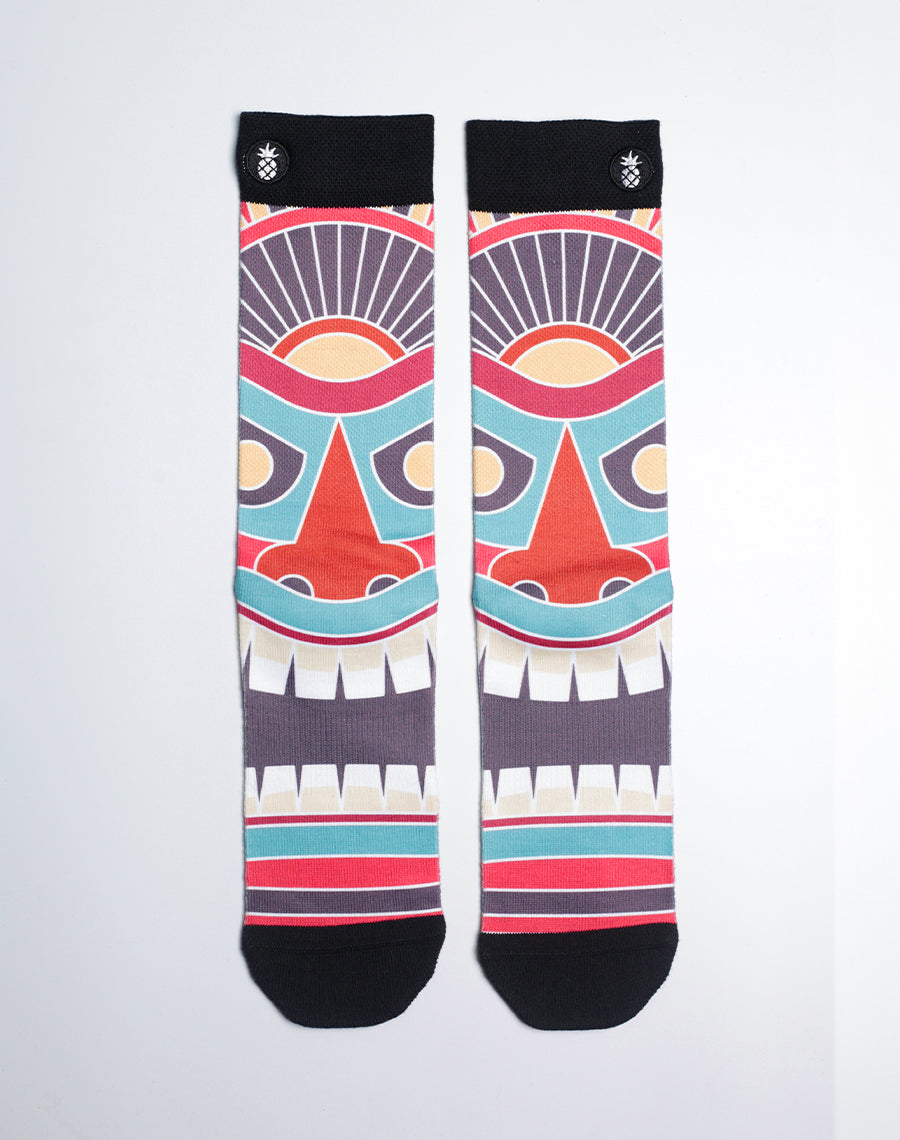 Tiki Totem Toes Printed Crew Socks with bold Hawaiian tiki mask design in sunset orange, ocean blue, and tropical red.