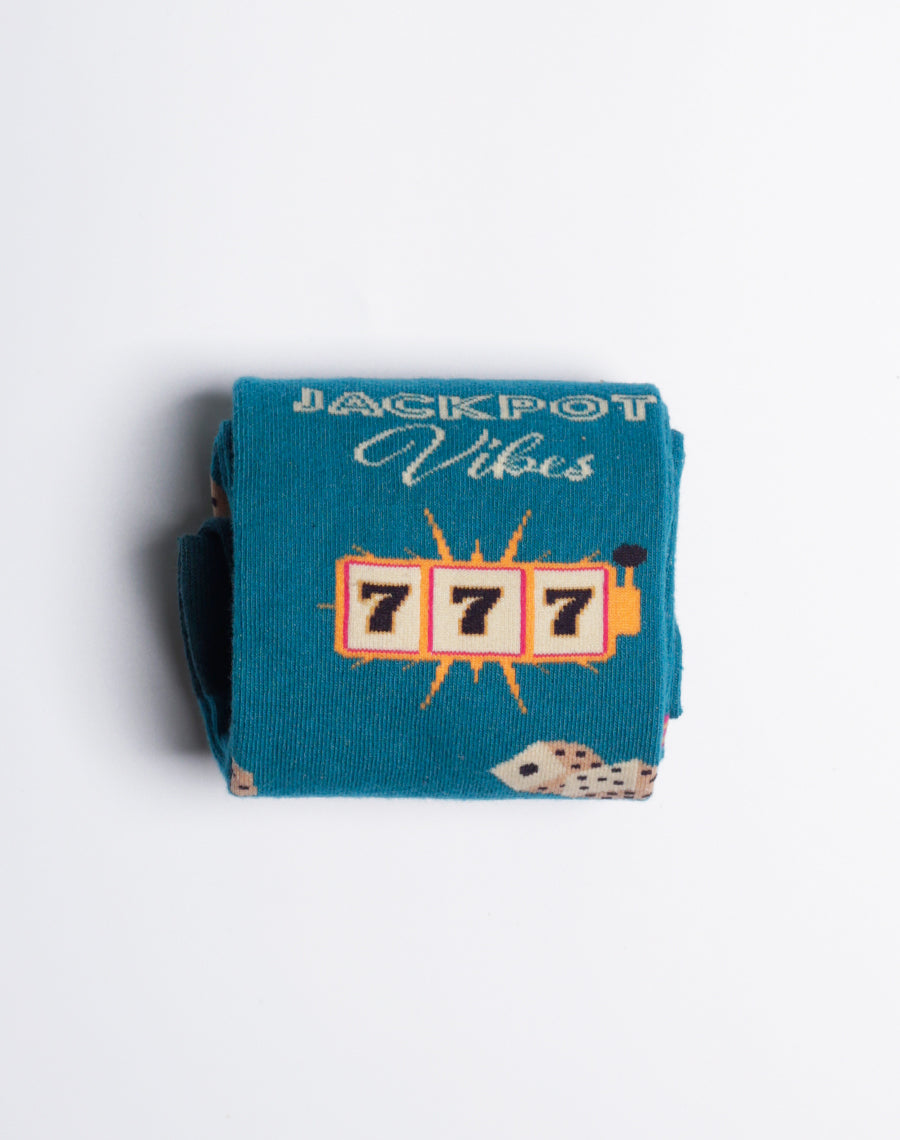 Jackpot Vibes teal crew socks for women, highlighting Las Vegas-themed icons like slot machines, dice, and cards.