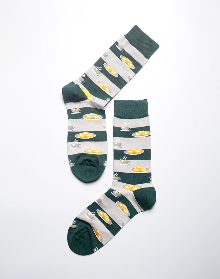 Green novelty socks with beignet and coffee illustrations