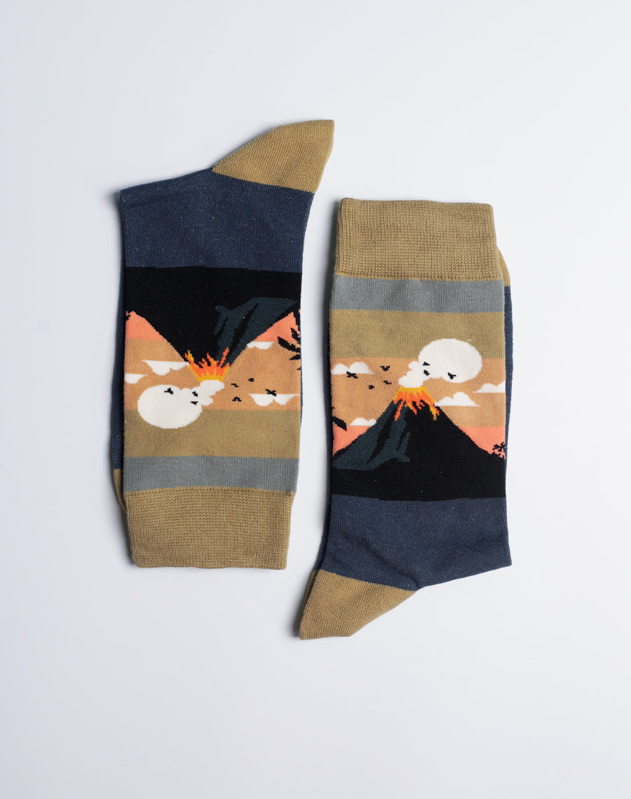 Gold and navy blue cotton socks featuring an erupting volcano, inspired by tropical island landscapes.