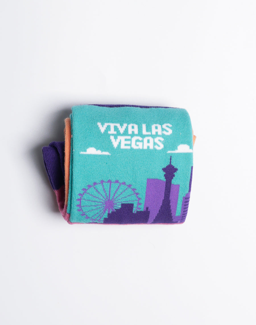 Playful socks featuring the 'Viva Las Vegas' skyline in bold hues of purple, turquoise, and orange with palm tree details.