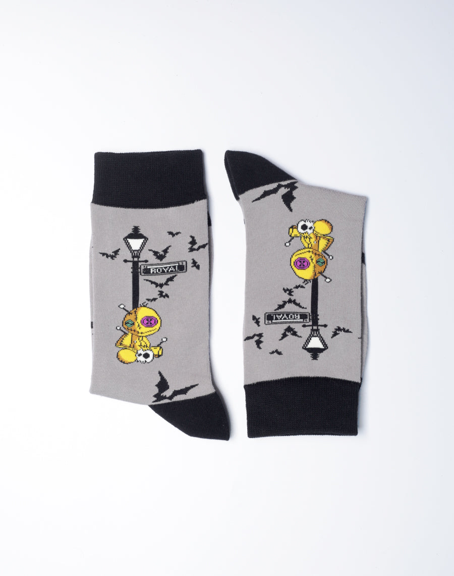 Yellow Voodoo doll sitting under the lamp - printed grey color socks with black heels